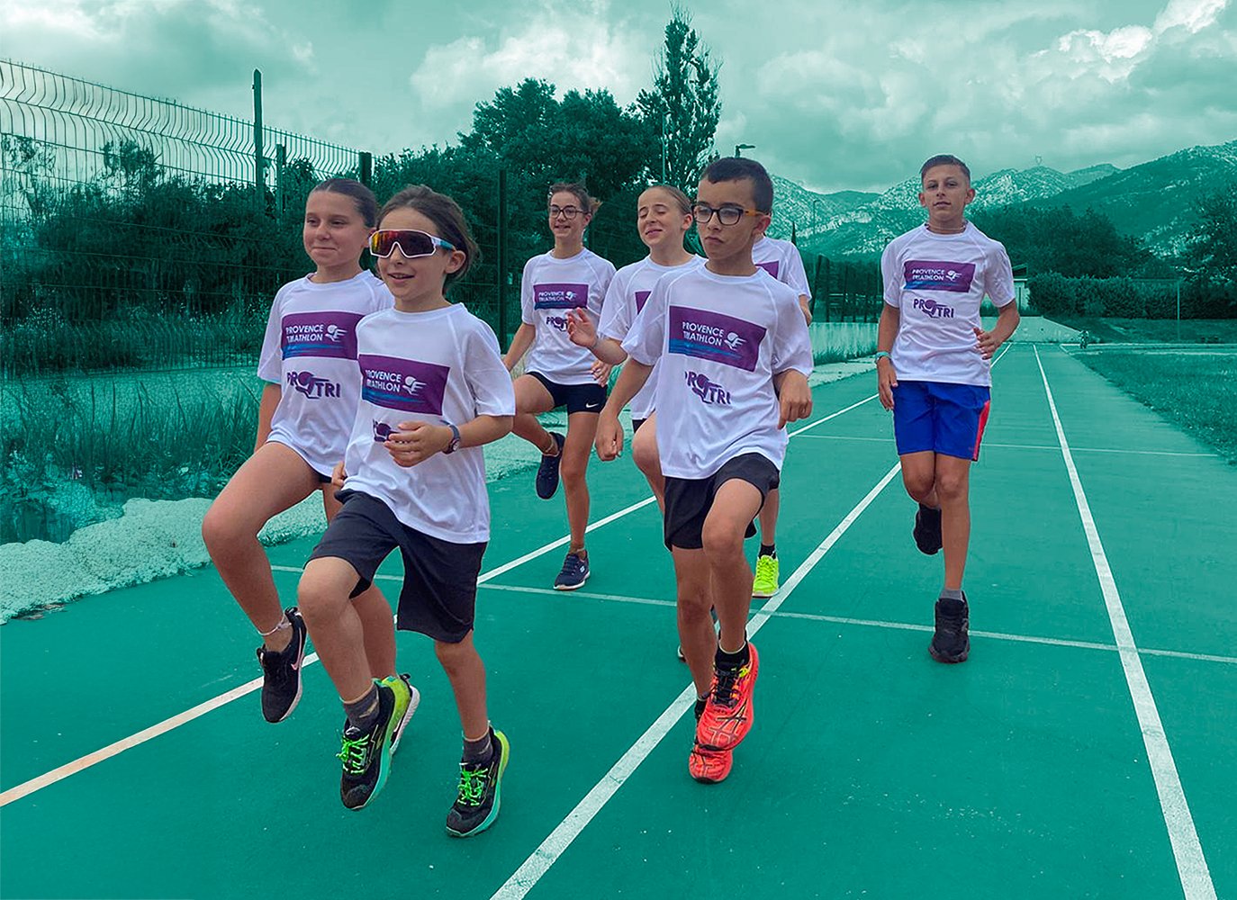 Enfants qui courent sur une piste d'athlétisme en groupe